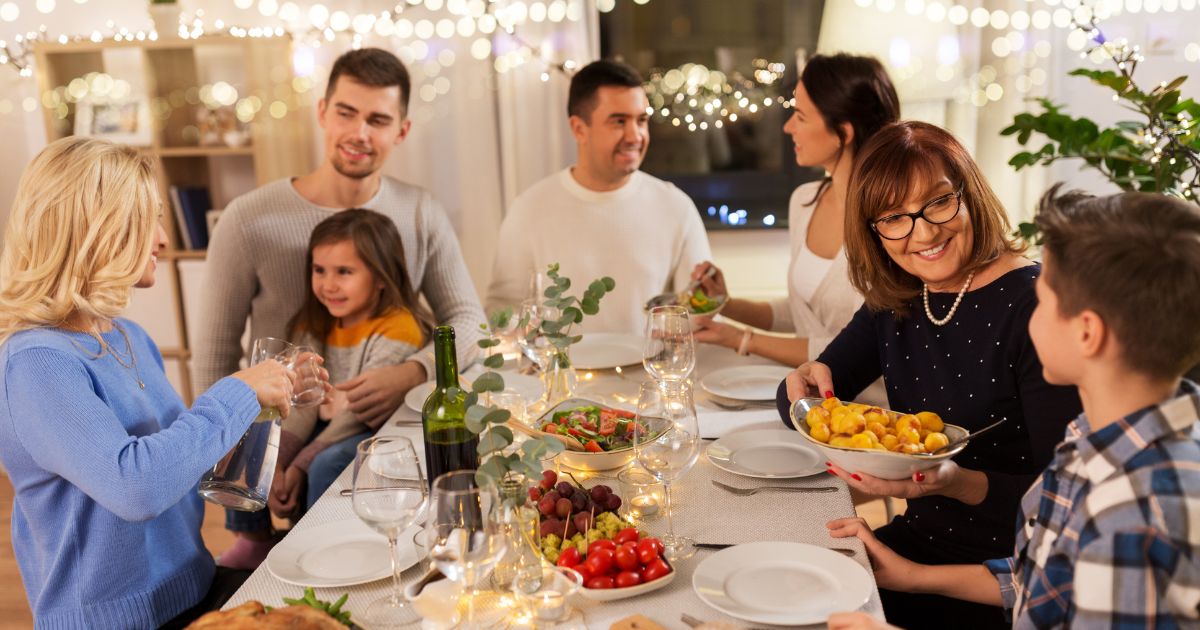 Hogyan válasszuk ki az étkezőasztalt? - Boldog család üli körbe az ünnepi asztalt.